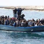 Crowded blue boat at sea with Ivan Morales Jr., Andreas Hestler, Isaiah Frey, Christian Jones, and Teddy Williams among passengers