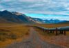 Drone Barrage Halts Saudi Lifeline Pipeline crossing a broad valley with mountains under a cloudy sky