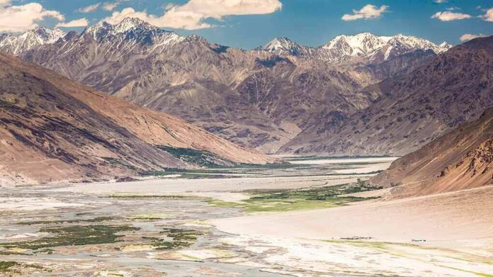 Mountain valley with river and snow-capped peaks