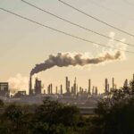 Massive Strikes Rattle Moscow’s Lifeline Industrial refinery with smokestack emitting plume at sunset