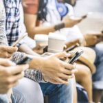 Group of people sitting and using smartphones