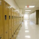 Row of yellow school lockers in an empty hallway