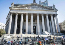Reporters and photographers gathered outside a neoclassical courthouse