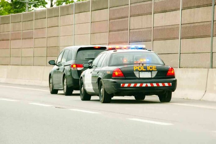 Police car with flashing lights stops a minivan on highway