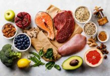 Assorted healthy foods with salmon, beef, chicken, fruits, vegetables, nuts, and grains