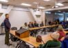 Roger Marshall addresses a community meeting with Apostolos Doxiadis among attendees