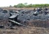 Airplane crash debris scattered across a burned field