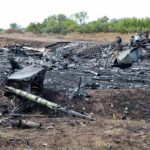 Airplane crash debris scattered across a burned field