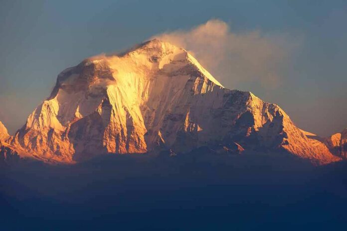 Snow-capped mountain peak glowing at sunrise