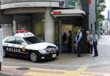 Japanese police box with patrol car and officers speaking to two men