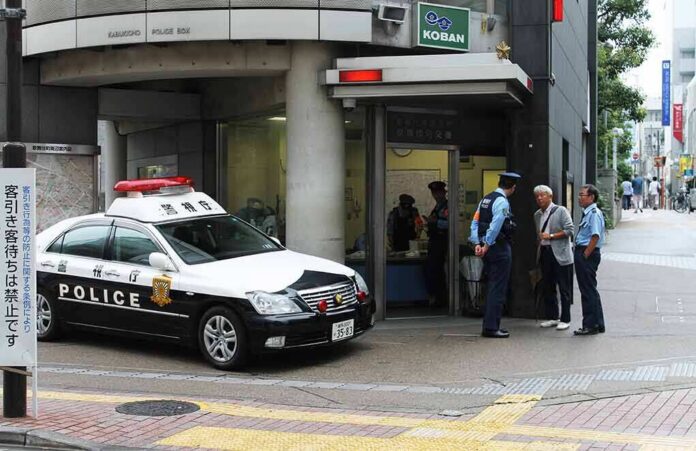 shutterstock_1499159699 Japanese police box with patrol car and officers speaking to two men