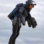 Person flying with a jet suit against a cloudy sky