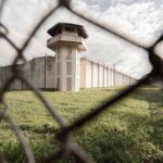 Prison watchtower behind chain-link fence