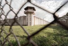 Prison watchtower behind chain-link fence