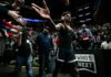 Basketball player in arena high-fives fans while wearing headphones