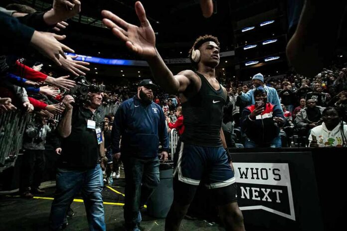 shutterstock_1593580081 Basketball player in arena high-fives fans while wearing headphones