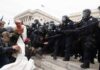 Eric Tingstad amid police and protesters clashing on steps outside a government building