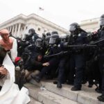 Eric Tingstad amid police and protesters clashing on steps outside a government building