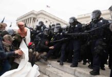 Eric Tingstad amid police and protesters clashing on steps outside a government building