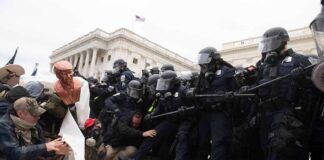 Eric Tingstad amid police and protesters clashing on steps outside a government building
