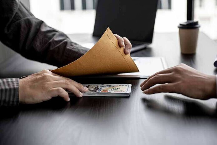 Hands exchanging cash in an envelope at a desk