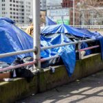 Man Returns From Shopping to Find Home Gone Tents covered with blue tarps along a city sidewalk