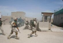 6 American Soldiers Killed, Warnings Allegedly Ignored Soldiers in desert uniforms run past a checkpoint amid dust