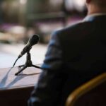 Microphone on a table near a seated person in a suit