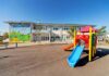 Playground with colorful slide in front of a school building
