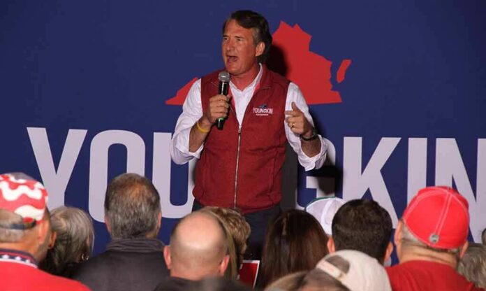 man speaking on stage at a rally