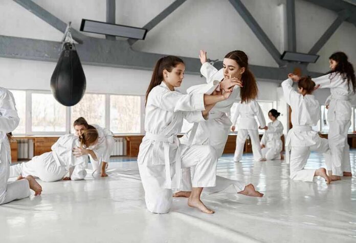 martial arts students practicing grappling in a dojo
