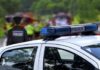 Reporter Jumps Clear as Car Veers Toward Him Police car with blue light bar at roadside scene