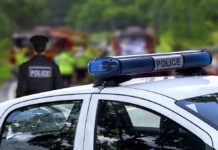 Police car with blue light bar at roadside scene