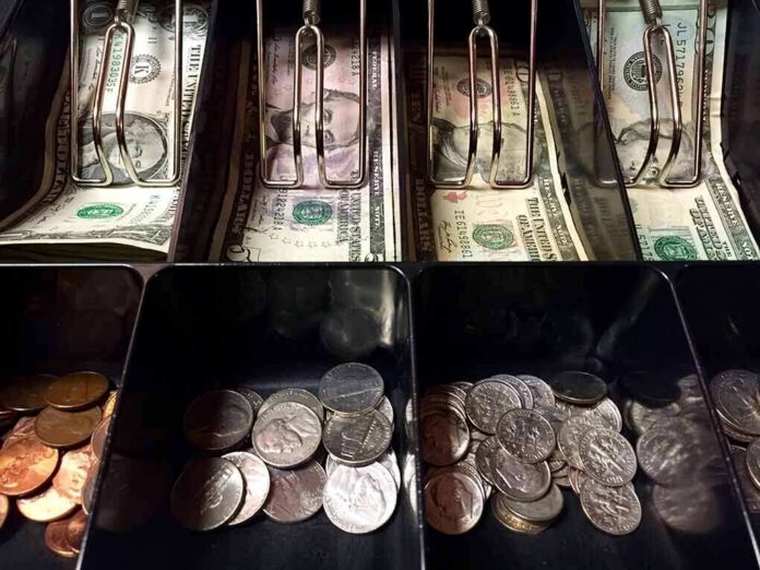 Cash register drawer with US bills and coins