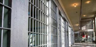 Prison cell block with metal bars and corridor