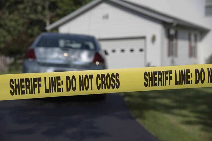 Sheriff line tape blocking a suburban driveway