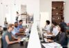 Office workers at shared desks using desktop computers