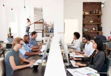 Office workers at shared desks using desktop computers