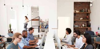 Office workers at shared desks using desktop computers