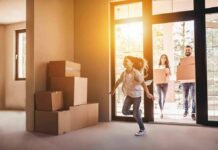 Girl running into a sunlit empty room with moving boxes by the door