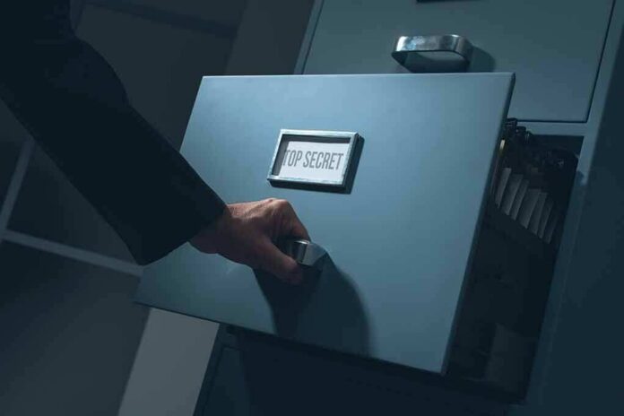 Hand opening a filing cabinet drawer labeled top secret